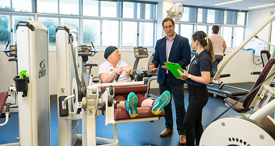 people standing in gym surrounded by fitness machines